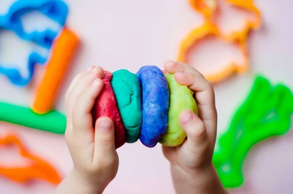 Çocuk elleri renkli kille oynuyor. Ev yapımı plastik.