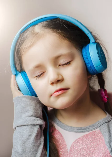 Little Girl Blue Headphones Holding Smart Phone Hands Sitting Bed — Stock Photo, Image