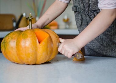 Cadılar bayramı, dekorasyon ve tatil konsepti için balkabağı oydum. Küçük kız ve annesi evde balkabağı ya da balkabağı kabağı oyuyorlar. Helloween konsepti