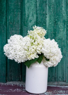 Eski ahşap arka planda beyaz ortanca buketi