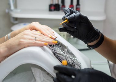 Manikür ustası kuafördeki müşteriye manikür yapıyor. Neil önemsiyor. Kapat.