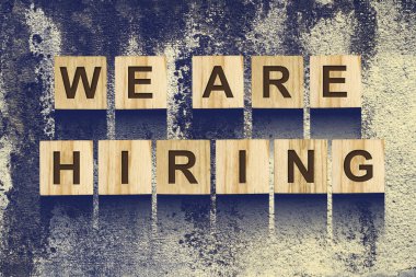 İşe vardı. Bir eski beton duvar ahşap yapı taşları ve arka plan üzerinde bir yazıt. Kavram iş arama.