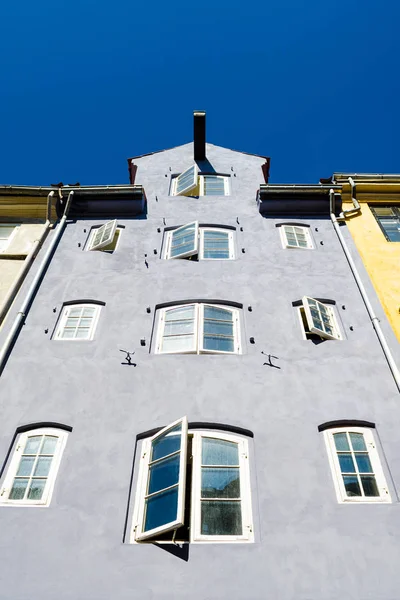 Old beautiful European building with old windows against the blue sky. View from below. Architecture. Europe. Travels.