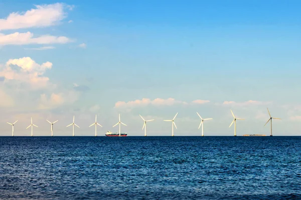 Wind turbines in the sea, on a sunny summer day. Blue sky. Ecological energy. Denmark. Baltic Sea.