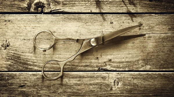 Concept Barber Shop. Old hairdressing scissors on a wooden background. Toned. Sepia. Copy space Beauty.