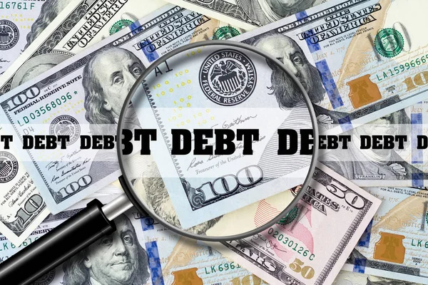 Dívida, vista através de uma lupa na inscrição no fundo das notas de dólar. Finanças de Empresas . — Fotografia de Stock