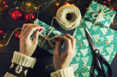 Kızın hediyeler Noel ağacının altına koyar. Aydınlık çelenk ile. Üstten görünüm. Yeni yıl. Noel arka plan.