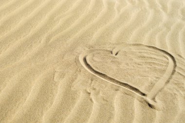 Kalp kontur sarı kum üzerinde. Anneler günü, Sevgililer günü arka plan.