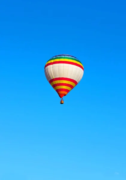 Beautiful multi-colored flying balloon. against the blue sky. Type of rest.