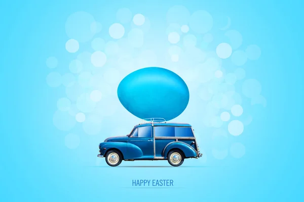 Easter background with a blue car with an Easter multi-colored egg on the trunk. Blue background. Copy space.