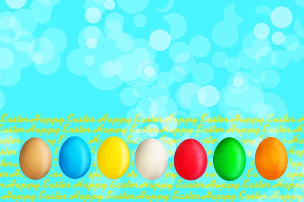 Happy Easter, word written on wooden blocks on blue background with multicolored easter eggs. Copy space. Place for text. Easter. — Stock Photo, Image