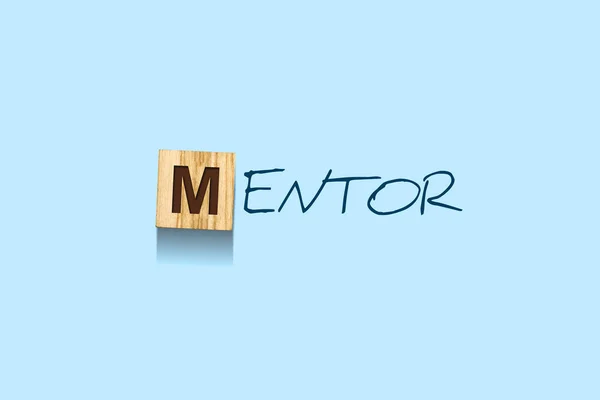 Mentor. Words written on a wooden block. Blue background. Isolated. Business.