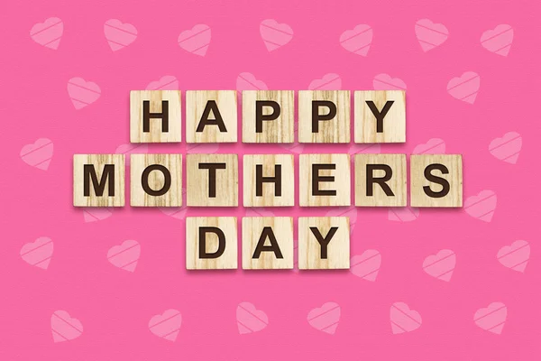 Glücklicher Muttertag, Wort auf Holzklötzen geschrieben. rosa Hintergrund. Glückwunsch-Hintergrund. Urlaubskarte. — Stockfoto