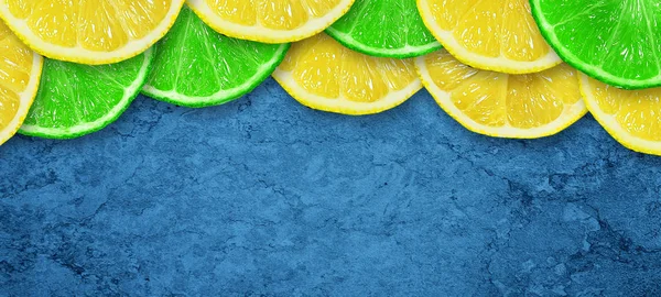 Trancher la lime juteuse et le citron sur un fond bleu foncé en béton. Espace de copie. Des fruits frais. Fond de fruits. Une nourriture saine. Des vitamines. Fête d'été. Anniversaire . — Photo