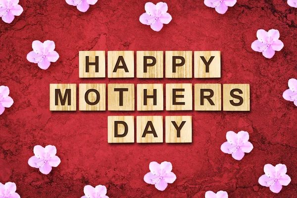 Glücklicher Muttertag, Wort auf Holzklötzen geschrieben. roter Hintergrund Gratulationshintergrund. Urlaubskarte. — Stockfoto