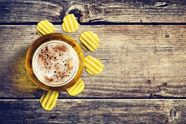 Glas kall öl och chips på en trä bakgrund. Översta vyn. Kopiera utrymme. Kalla sommar drinkar. — Stockfoto