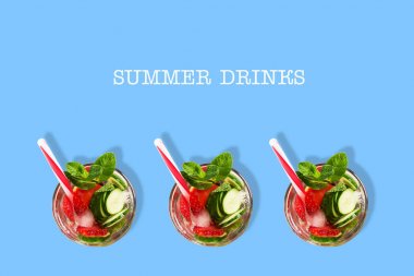 Mavi bir arka plan üzerinde salatalık, çilek, nane ve buz ile Kokteyl. Üst te. Kopya alanı. Metin için yer. Yaz içecekleri.