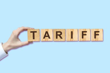 Tarife, kadın el mavi bir arka plan üzerinde ahşap bloklar üzerinde yazıt yaptı. Izole. İş Finansmanı.