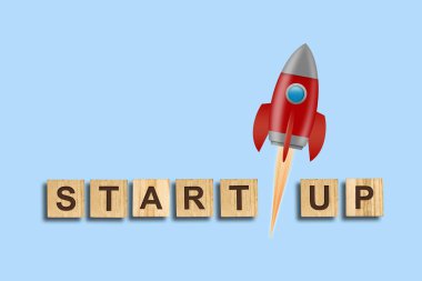 Konsept Başlat. Ahşap bloklar üzerine yazıt ve mavi arka planda kırmızı bir roket. Konsept teknolojisi lansmanı projesi. Iş.