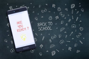 Yazıt okula geri, bir cep telefonu ekranında, hazırsınız. Çeşitli okul malzemelerinin arka planına karşı, elle çizilmiş. Arka plan.