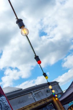 Mavi gökyüzüne karşı ampuller Sokak çelenk. Dış. Close.