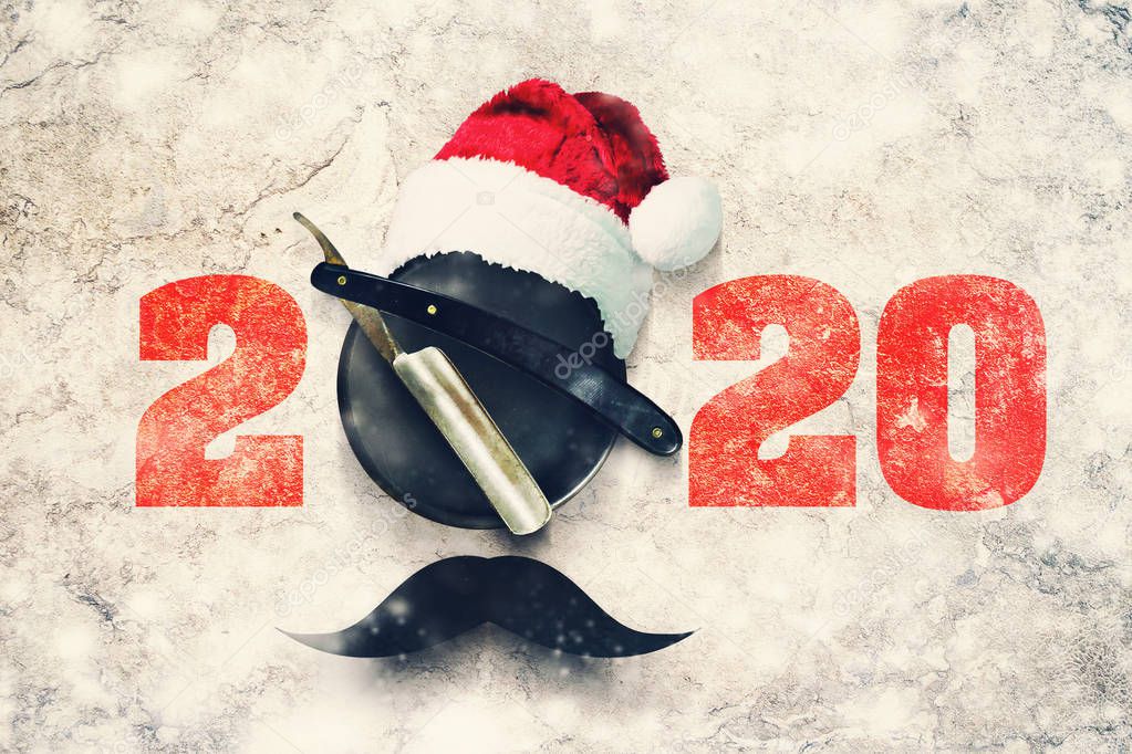 Razor on a plate for foam with a Santa Claus hat on a gray background. Inscription 2020. Greeting card Happy New Year and Merry Christmas for a hairdresser and barber shop.