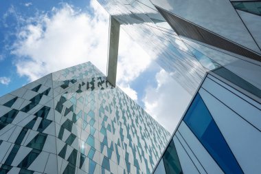 Kopenhag. Danimarka. 24 Temmuz. 2019: Bir cam binanın cephesi. Bulutlu gökyüzü Alt görünümü. Close. Mimari.