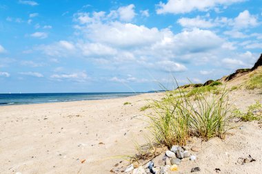 Kumlu plajlı güzel bir deniz manzarası ve güzel bulutlu bir gökyüzü. Danimarka. Kuzey Denizi. Doğa. Rahatlama