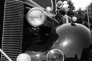 Eski bir arabanın far ve radyatör ızgarası. Siyah beyaz fotoğrafçılık. Yakın plan. Ayrıntılar. Motorlu taşıma.