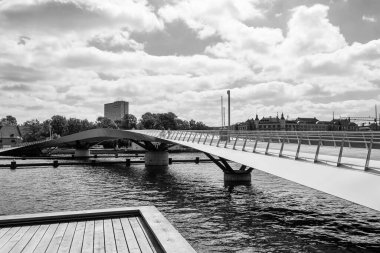 Güzel bir yaya, kanalın üzerinde bisiklet köprüsü. Danimarka. Kopenhag. Siyah beyaz fotoğraf. Mimari Gezileri Gezer