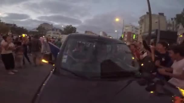 Paris, Frankreich - 15. Juli 2018: Jubelnde Menge junger Kerle umringt Auto auf der Fahrbahn. Mädchen im Auto filmt auf Smartphone, was passiert — Stockvideo