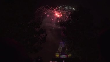 Gece gökyüzünde havai fişekler. Eyfel Kulesi de 3D projeksiyon gösterisi renkli ışıklar.