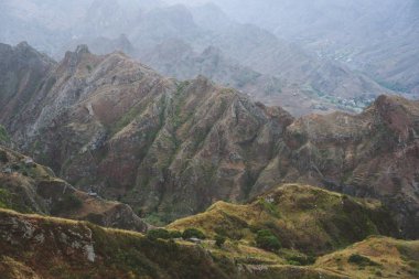 Kenarları, vadiler ve sarı çim ve yeşil mango ağaçları ile kaplı tepeler üzerinde bazı evlerin şudur dağlar ridge için görüntüleyin