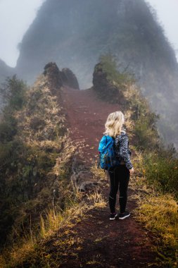 Dağ sırtı Santo Antao Adası, Cape Verde dar puslu yolunda sırt çantası ile kadın uzun yürüyüşe çıkan kimse