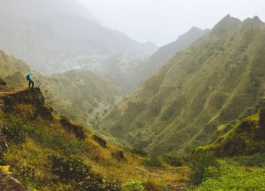 Fiyatı dağ kenar üstünde sırt çantası ile. Kayalık arazi Yüksek Sıradağlar derin geçit ve kıyı şeridi inanılmaz panorama görünümünü önünde. Santo Antao Cape Verde