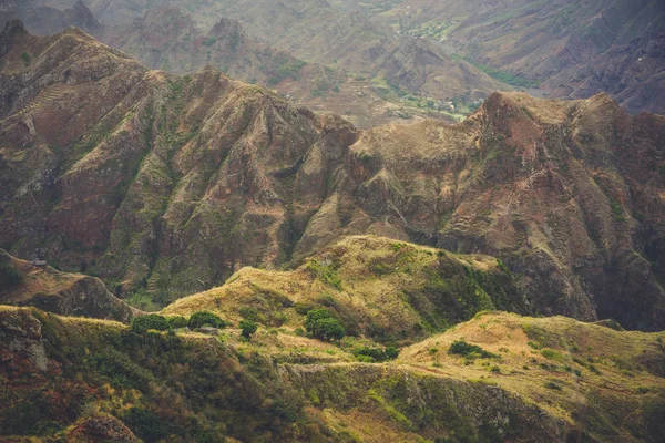 Επισκόπηση της κορυφογραμμής ιλιγγιώδης βουνά με κάποιες κατοικίες, κοιλάδες και κορυφές καλύπτονται με κίτρινο γρασίδι και δέντρα πράσινο μάνγκο — Φωτογραφία Αρχείου