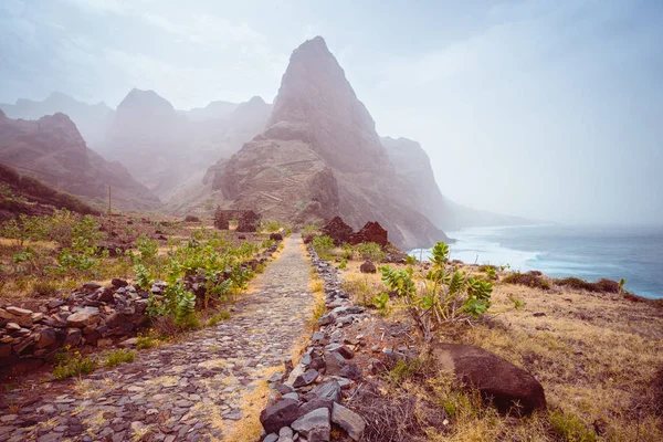 Panoramic view of stony hiking path to Ponta do Sol over amazing arid Aranhas valley with huge mountain peak and house ruins. Santo Antao Island, Cape Verde — Stock Photo, Image