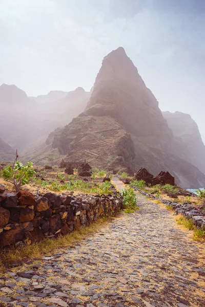 Panoramic view of stony hiking path to Ponta do Sol over amazing arid Aranhas valley with huge mountain peak and house ruins. Santo Antao Island, Cape Verde — Stock Photo, Image