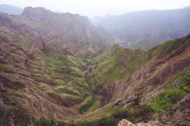 Bir dik geçit haze nehir yatağı ve yemyeşil yeşil bitki örtüsü Delgadinho Vadisi dağ sırtı ile nefes kesen Panoraması. Santo Antao, Cape Verde