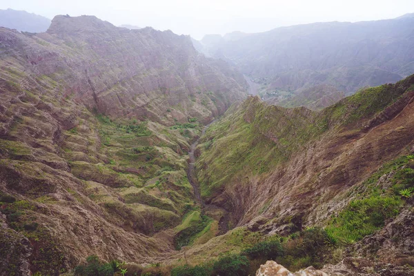 Bir dik geçit haze nehir yatağı ve yemyeşil yeşil bitki örtüsü Delgadinho Vadisi dağ sırtı ile nefes kesen Panoraması. Santo Antao, Cape Verde