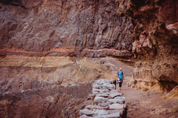 Turist kadın zammı uzun yol cliff ve kayalık tehlikeli kıyı şeridi boyunca Cruzinha Ponta için yapmak Sol. büyük yürüyüş yolunda dağ duvarları vardır. Santo Antao Adası, Cape Verde
