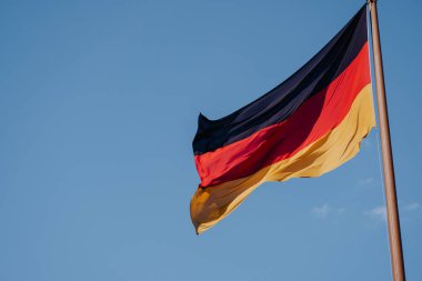 Mavi gökyüzü arka plan üzerinde Alman ulusal bayrak