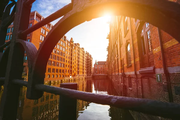 Speicherstadt Hamburgo. Famoso marco de edifícios antigos feitos com tijolos vermelhos. Ponte e raios de sol em visão de baixo ângulo — Fotografia de Stock