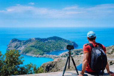 Yaz tatil hafta sonu Yunanistan Avrupa ziyaret etti. Yakalama zaman atlamalı üstten görünüm noktası platformdan Akdeniz köyü Assos zevk sırt çantası ile erkek serbest fotoğrafçı. Tripod üzerinde kamera