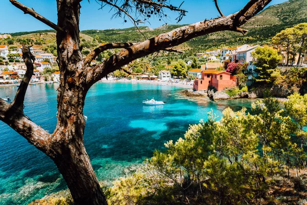 Widok na zwiedzanie przezroczystej zatoce śródziemnomorskiej miejscowości Assos oprawione przez zielony sosnowy gaj. Wzór cienia. Kefalonia Grecja — Zdjęcie stockowe
