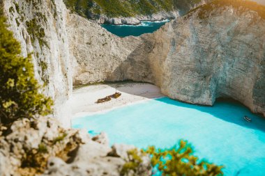 Navagio plaj batık kumlu plaj ve parlak güneş ışığı büyük beyaz kayalıklarla çevrili turkuaz mavi deniz suyu ile. Ünlü konum adada Zakynthos, Yunanistan
