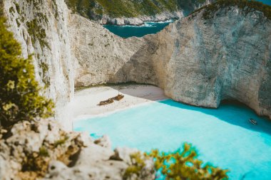 Navagio plaj tarafından büyük beyaz kayalıklarla çevrili turkuaz mavi deniz suyu ile ünlü gemi enkazı. Ünlü dönüm noktası konumu adada Zakynthos, Yunanistan. Yaprakları arasında vurdu Farme