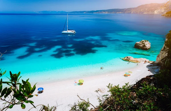 Fteri beach, Kefalonia Kefalonia, Yunanistan. Açık mavi deniz suyu beyaz Katamaran yat. Turistler gök lagün yakınındaki kum plajındaki