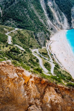 Ünlü Myrtos Beach aşağı serpantin zikzak yol. Turuncu kayalar vadinin yanında. Güneşli Plaj görünüm noktası platformu, Kefalonia, Yunanistan