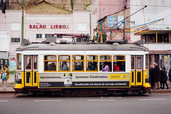 LISBONA, PORTOGALLO - 31 dicembre 2017: Vista sulla strada con il famoso tram storico turistico giallo. Famosa attrazione turistica d'epoca. Architettura colorata città edifici scena di strada, Portogallo — Foto Stock